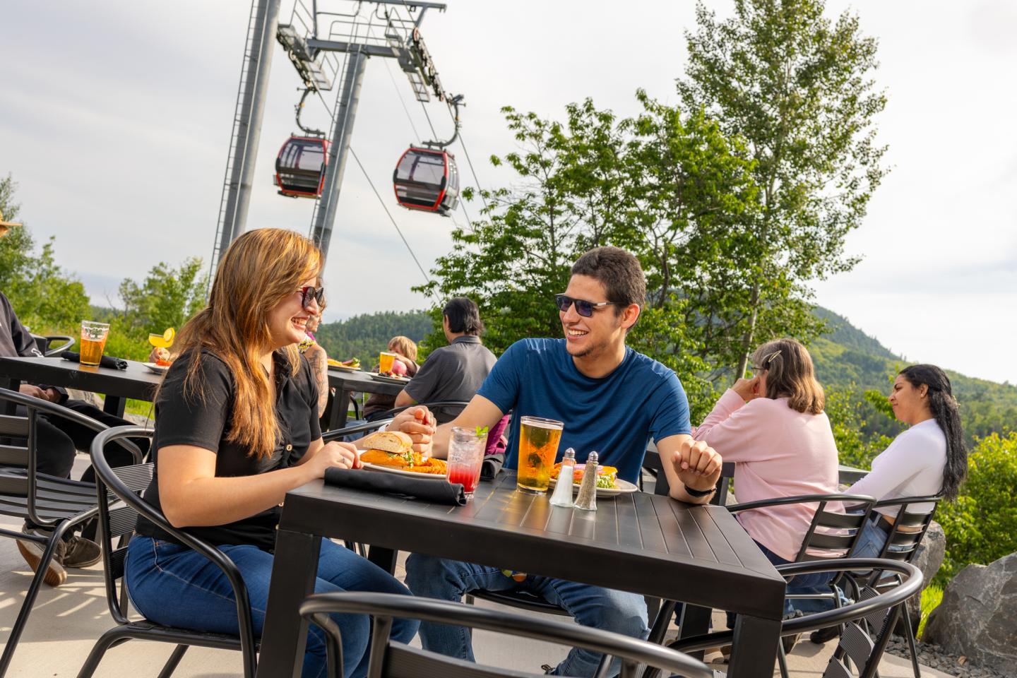 Two people dining outdoors, cable cars in the background.