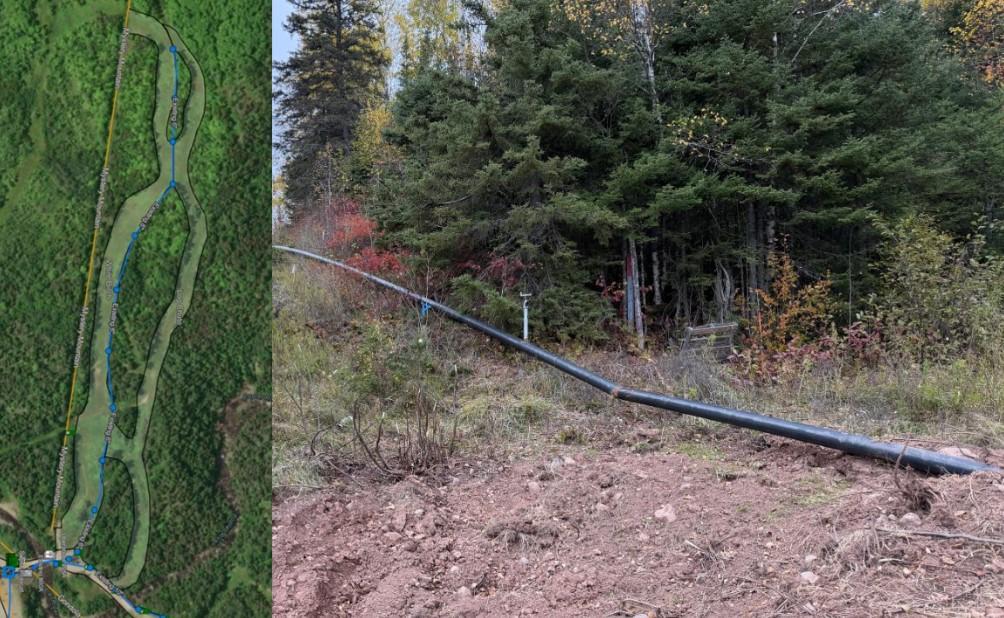 Pipeline runs through forested area with dirt path and lush greenery.