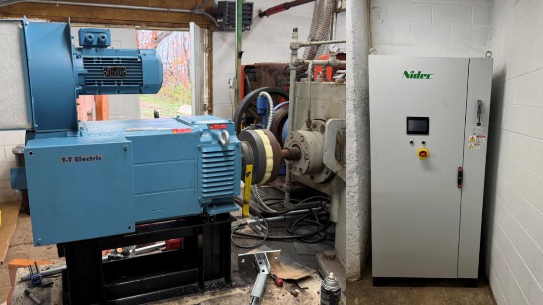 Blue generator machine next to a white control panel in an industrial space.