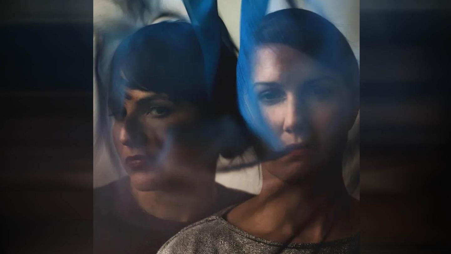 Two blurred faces overlaid with abstract blue streaks.