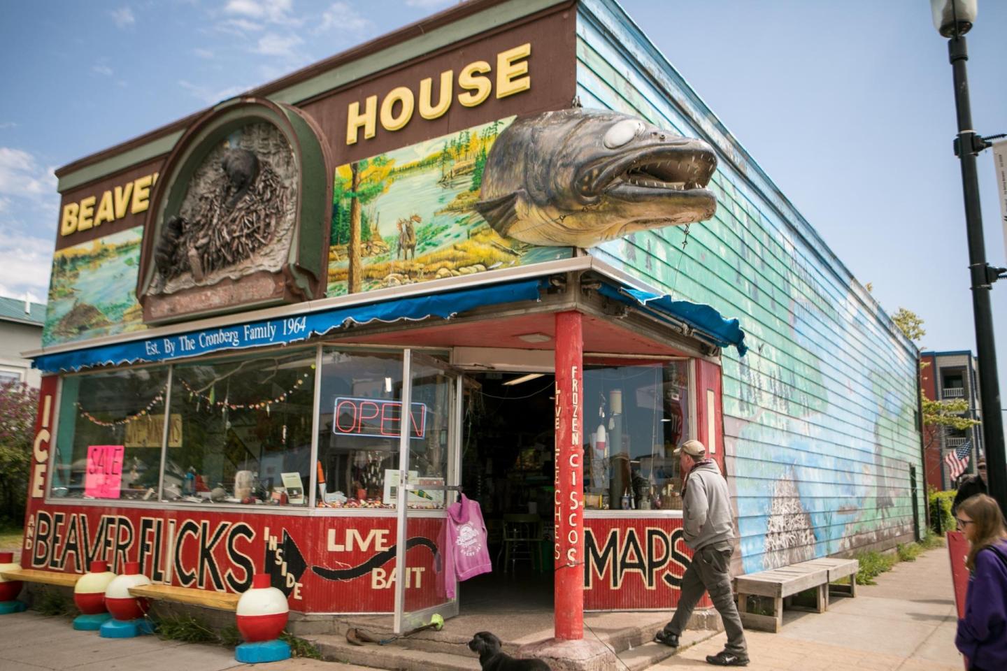 Quirky store with fish decor and colorful murals, people walking by.