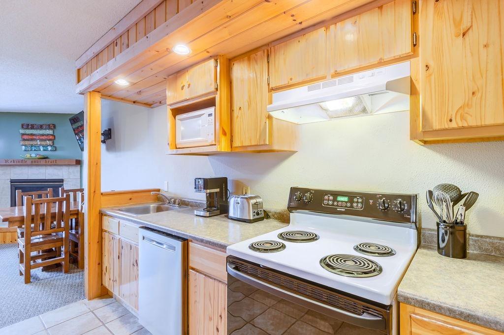 Cozy kitchen with wood cabinets, white stove, and countertop appliances.