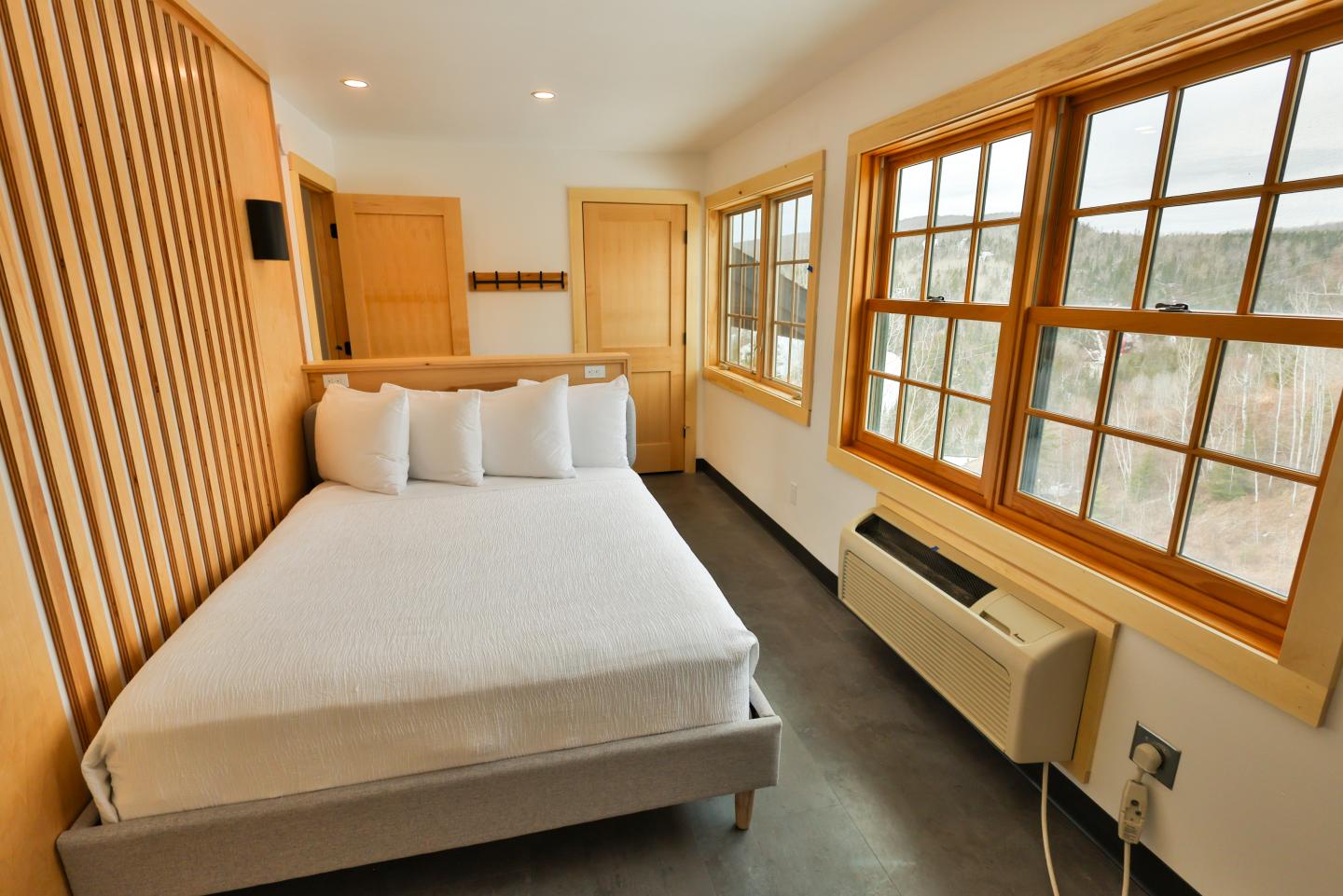 Cozy bedroom with a large window and wooden accents.