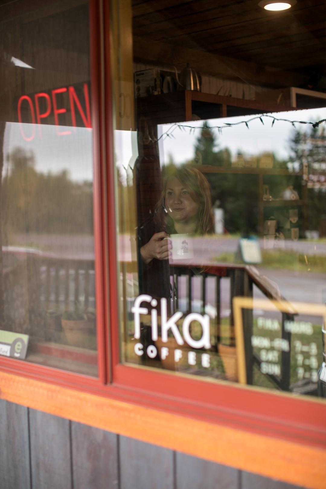 Coffee shop window with neon “OPEN” sign and Fika Coffee logo.